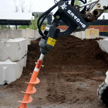 Bobcat Auger Attachment in front of a pile of mulch